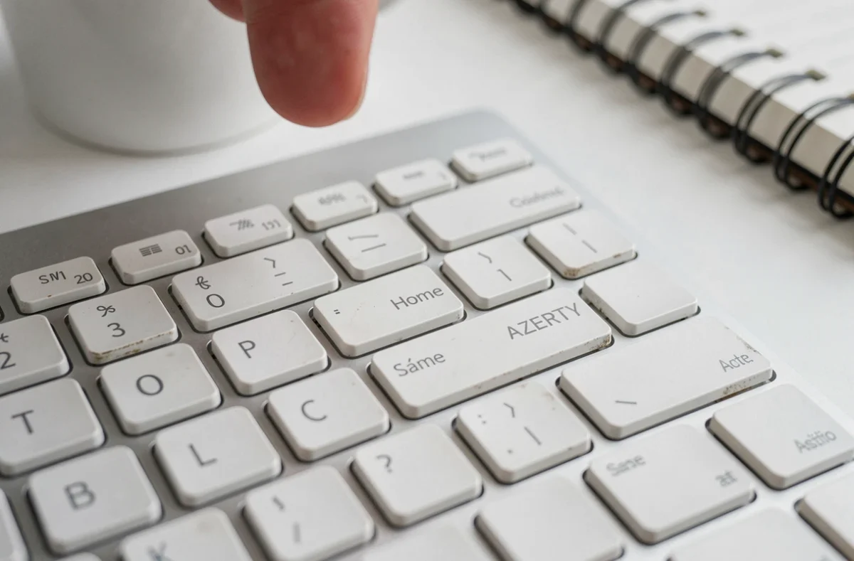 Gros plan sur la touche Home d'un clavier AZERTY avec texture détaillée des touches dans un espace de travail épuré